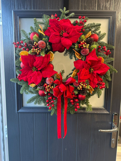 Classic Red Velvet Wreath - Make a striking festive statement with the Classic Red Velvet Christmas Wreath. Handcrafted with fresh evergreen foliage, this luxurious design is beautifully adorned with rich velvet accents, seasonal berries, decorative baubles, pinecones, dried citrus slices, and finished with an elegant cascading ribbon. Bursting with traditional Christmas colours and timeless charm, this wreath is the perfect way to welcome family and friends throughout the festive season.