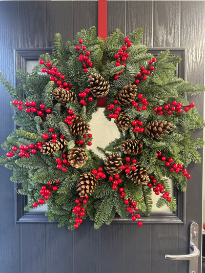 Classic Pinecone & Berry - Celebrate the beauty of a traditional Christmas with the Classic Pinecone & Berry Christmas Wreath. Handcrafted with fresh evergreen foliage, this timeless design is adorned with natural pinecones and vibrant red berry clusters, creating a rich, woodland-inspired display. With its elegant simplicity and classic festive colours, this wreath offers a warm and welcoming touch to any front door, making it a perfect choice for the holiday season.